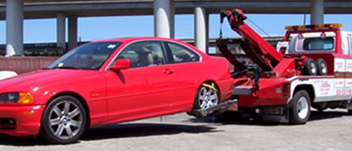red car being towed by towtruck